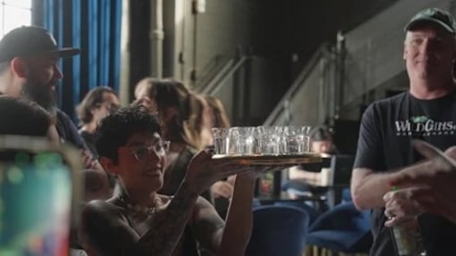 Waitress carrying a tray of WildGin shots